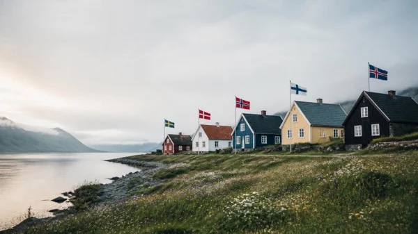 A row of traditional Nordic houses along a fjord flying the Swedish, Danish, Norwegian, Finnish, and Icelandic flags, illustrating Nordic leadership examples across companies