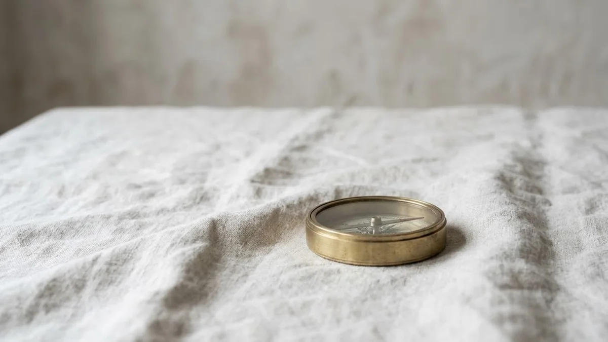 A brass compass resting on a wrinkled natural linen cloth, illustrating an honest guide to the performance improvement plan for managers