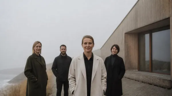 Female leader and team standing before modern Scandinavian wooden architecture in misty light, illustrating the flat-hierarchy Scandinavian leadership model